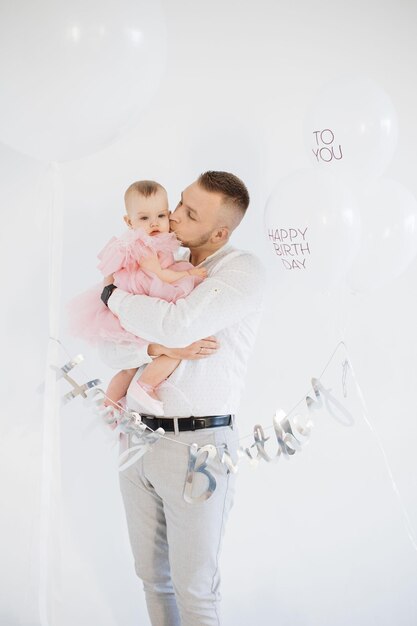 Dad gently embracing daughter during her first birthday