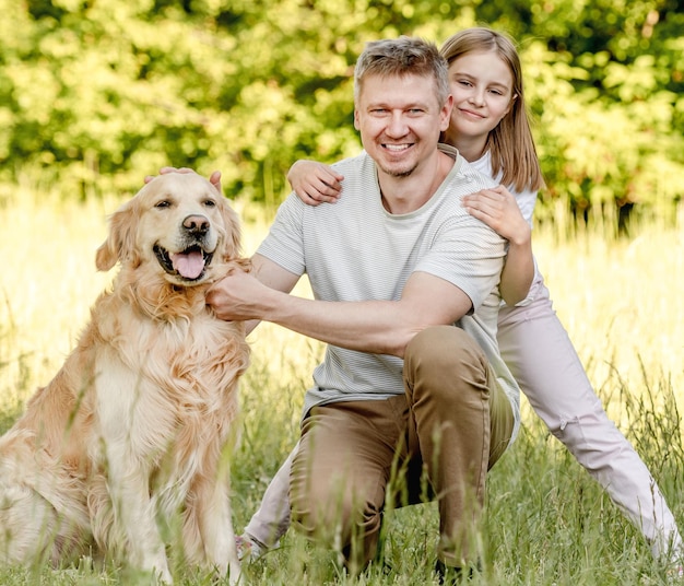 Dad and his daugter play with dog