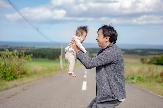 パパは長い道で赤ちゃんを抱きしめる