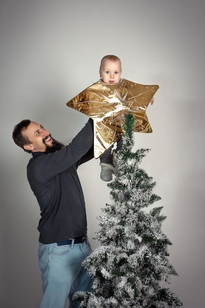 dad holding the baby like the top of the tree