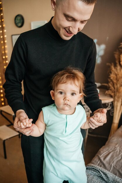 Photo dad holding the babys hands high quality photo