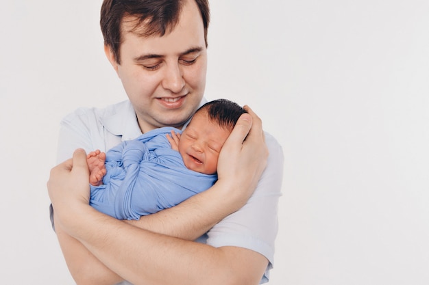 Dad holds the baby in his arms