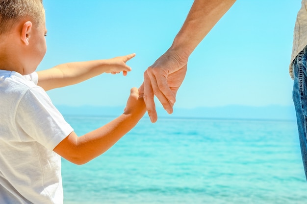 dad holds the hand of a child