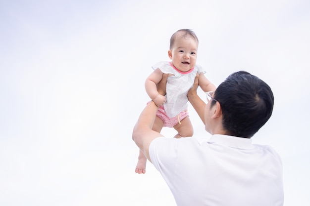 Photo dad holds and lifts his daughter into the sky