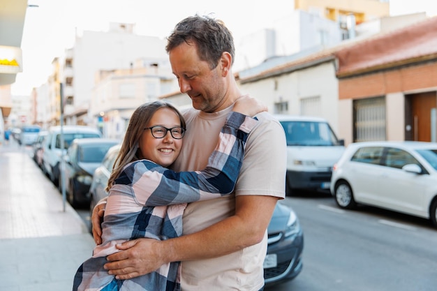 Dad hugs his daughter on a city street