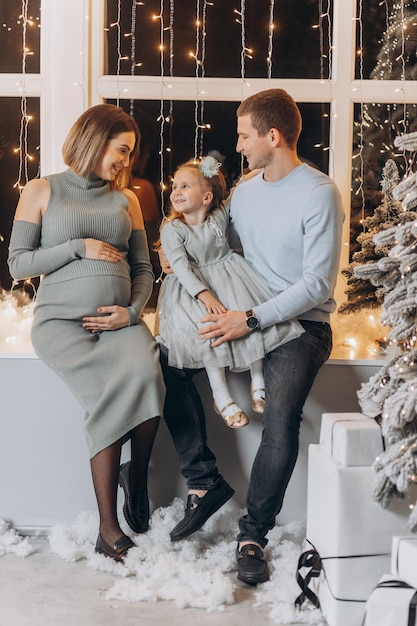 Dad, mom, and their daughter are celebrating Christmas