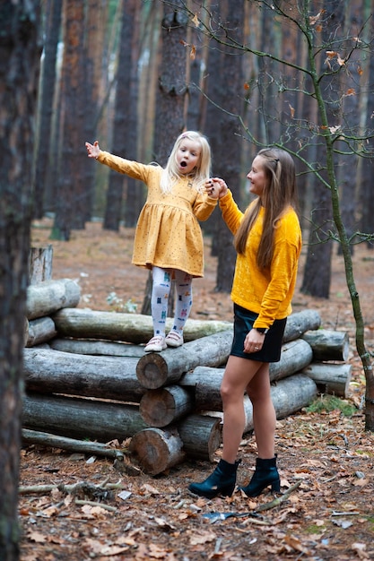 Dad and Mom with their daughter walk in the autumn in the forest Family in nature