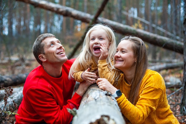 Dad and Mom with their daughter walk in the autumn in the forest Family in nature