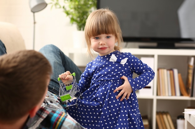 Foto papà gioca con la bambina carina in abito blu