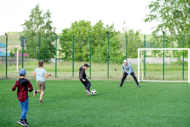 お父さんは夏に芝生で子供たちとサッカーをします