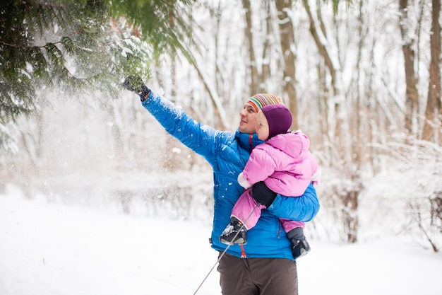 The dad showing his adorable little daughter on the snow