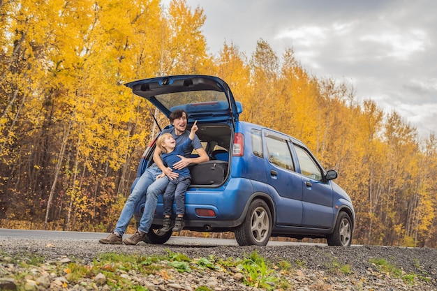 Dad and son are resting on the side of the road on a road trip Road trip with children concept
