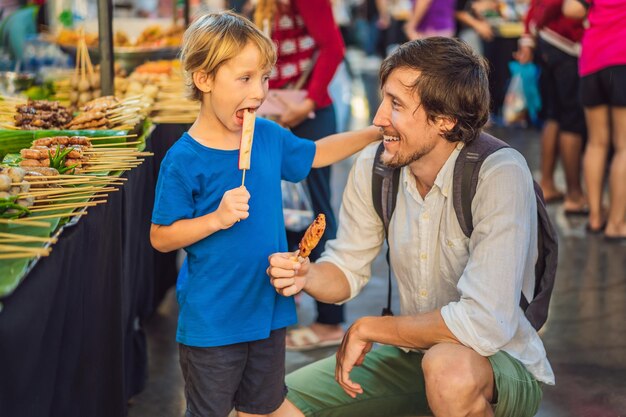 Dad and son are tourists on Walking street Asian food market