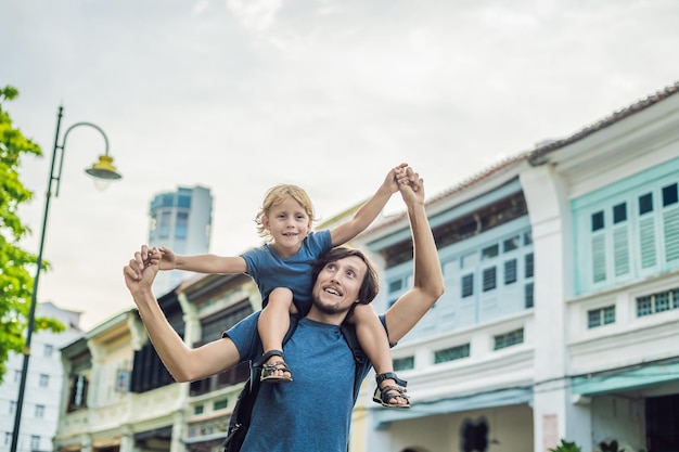 ジョージタウン、ペナン、マレーシアの旧市街の古い家の背景に父と息子
