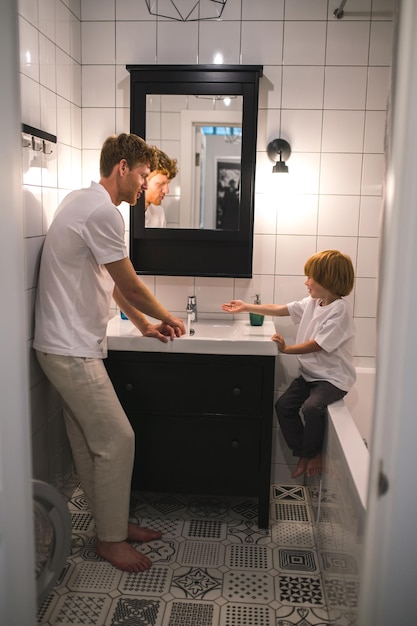 Dad and son in the batheroom getting ther morning procedures done