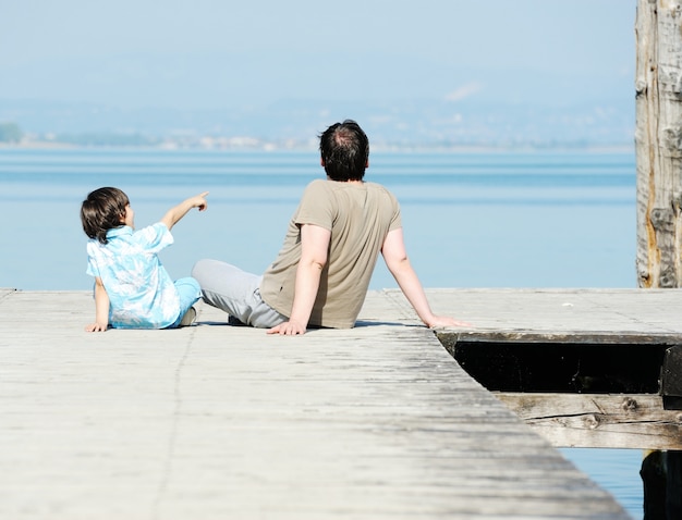 Dad and son by the dock on a beautiful lake