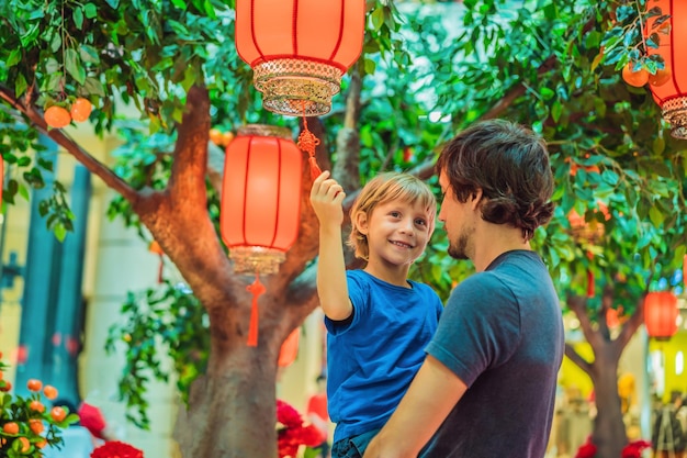 お父さんと息子は中国の旧正月を祝う中国の赤い提灯を見て