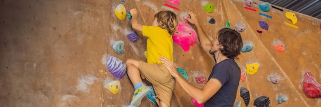 Papà e figlio al muro di arrampicata sport di famiglia stile di vita sano banner di famiglia felice formato lungo