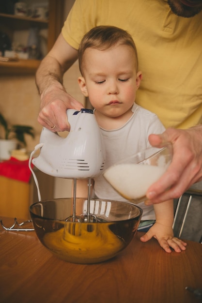 dad and son cook food at the kitchen table