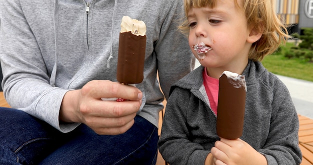 Foto papà e figlio che mangiano il gelato sul banco