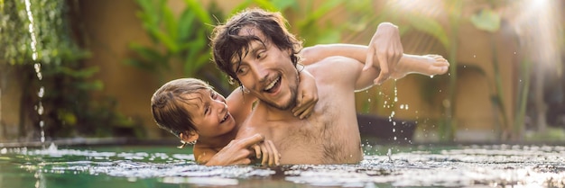 Dad and son have fun in the pool banner long format