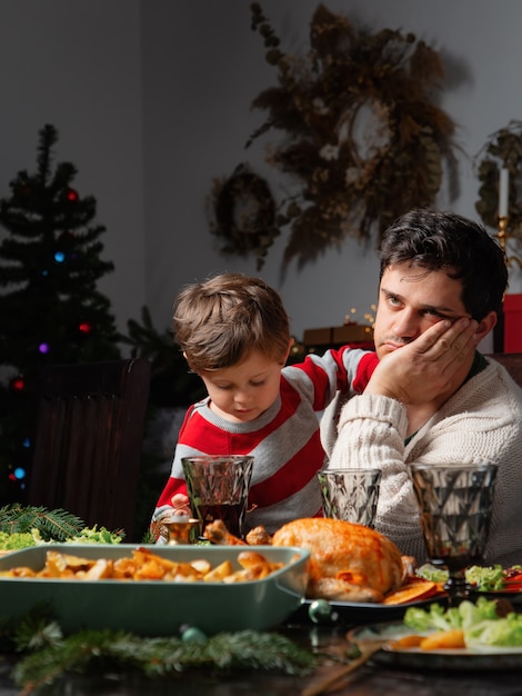 Papà e figlio si divertono a tavola durante la cena di natale