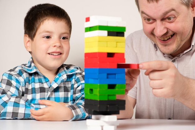 Dad and son play a board game of jenga