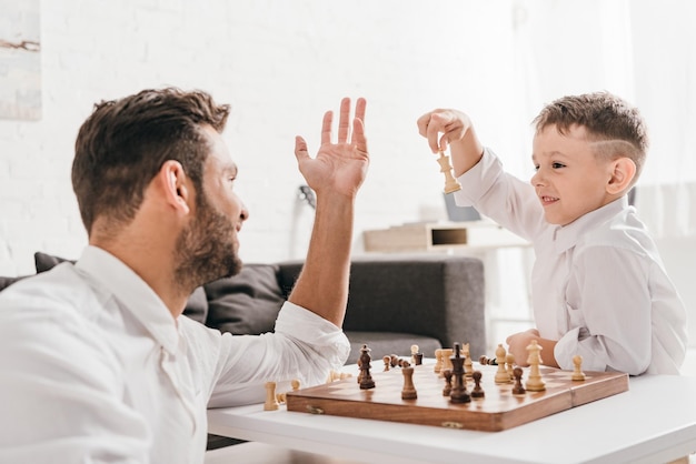 Dad and son playing chess together at home