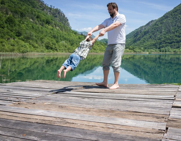 Papà e figlio che giocano sul lago di montagna