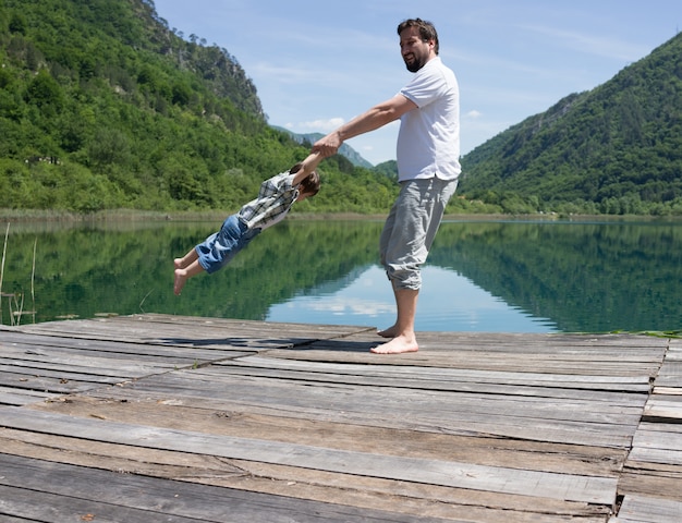 Dad and son playing on the mountain lake