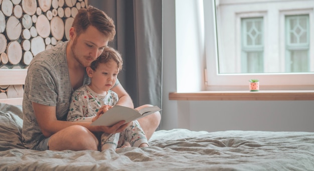 Dad and Son read a book together, smiling and hugging