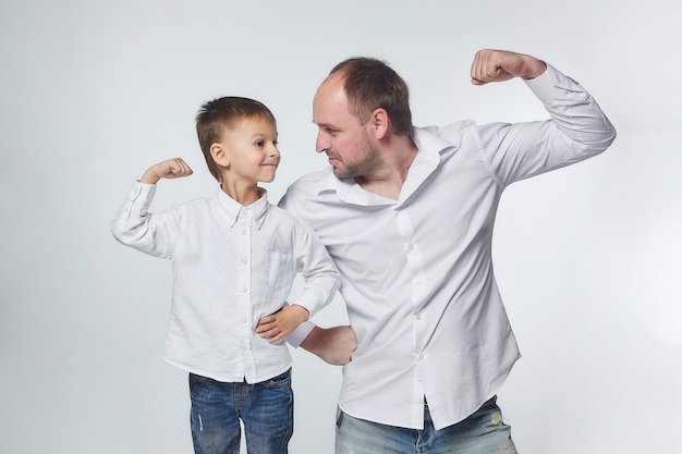 Dad and son show the strength of their biceps. fatherhood, psychology of relationships