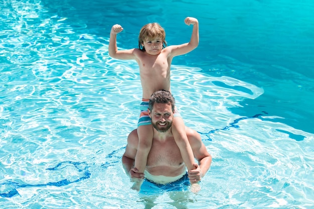 Dad and son in swimmingpool swimming lessons summer holidays fathers day