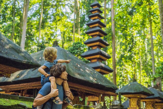 Dad and son travelers discovering Ubud forest in Monkey forest, Bali Indonesia. Traveling with children concept.