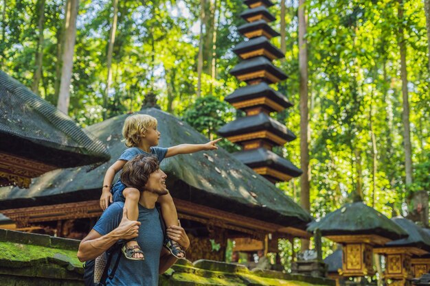 Dad and son travelers discovering Ubud forest in Monkey forest Bali Indonesia Traveling with children concept