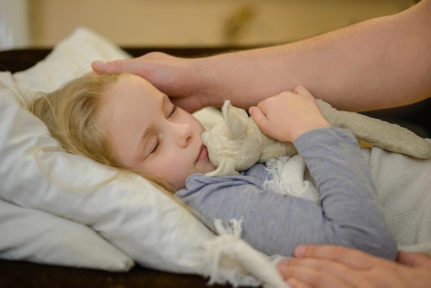 dad strokes his sick child looks with care tenderness and love holds the hand