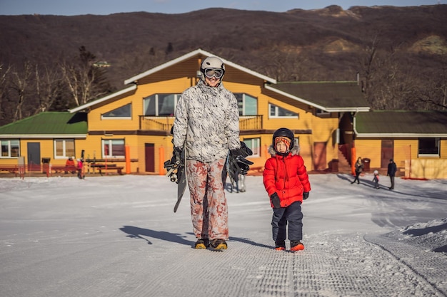 Dad teaches son snowboarding Activities for children in winter Children's winter sport Lifestyle