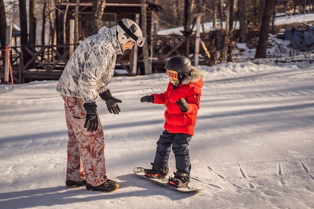 아빠는 겨울에 아이들을 위해 아들 스노우 보드 활동을 가르칩니다. 어린이 겨울 스포츠 라이프 스타일