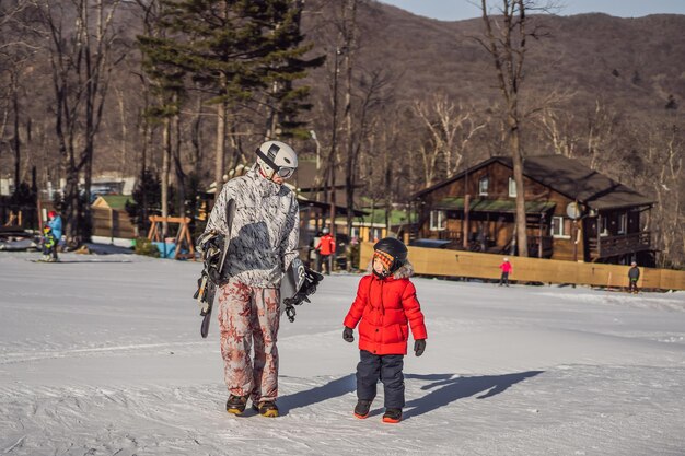 Dad teaches son snowboarding activities for children in winter childrens winter sport lifestyle