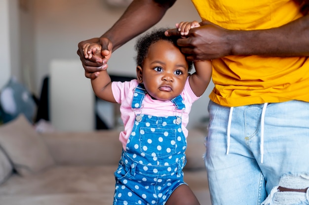 Papà che insegna al suo bambino di 9 mesi a camminare