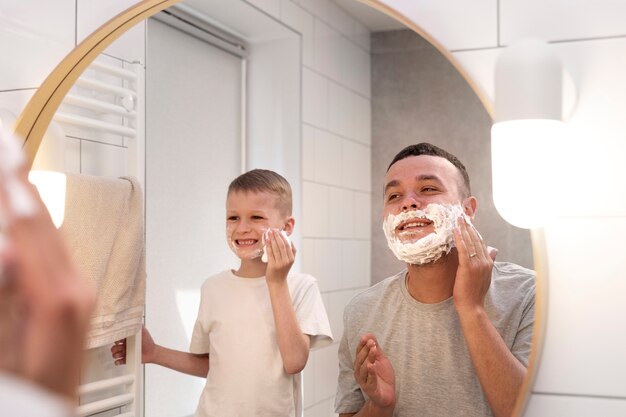 Dad teaching his son how to shave