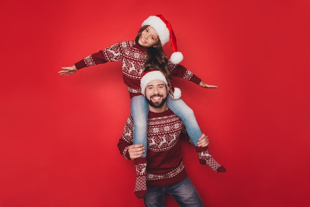 Dad with small woman fool in knitted traditional Christmas costumes with ornament