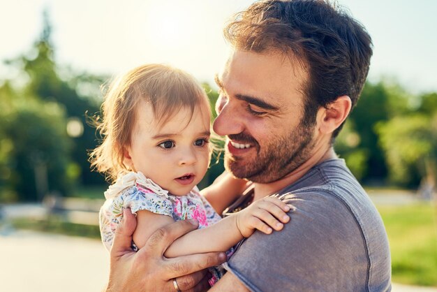 パパはあなたを行かせたくない彼の小さな女の子と屋外で若い父親のショット