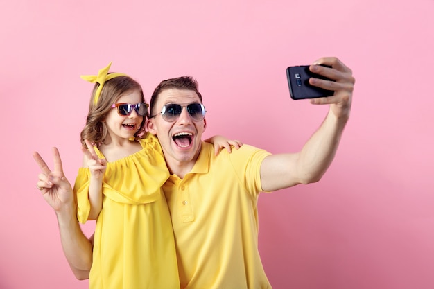 Daddy and little daughter doing selfie with smartphone