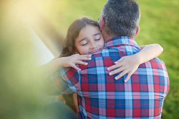 Daddy's little darling shot van een gelukkig klein meisje dat haar vader thuis knuffelt