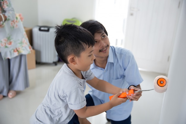 Daddy and son paint their new house