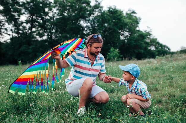 Daddy with little preschool boy fly a flying kite