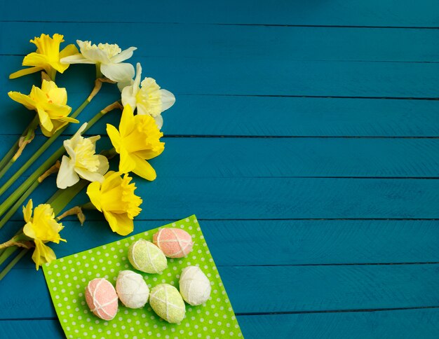 Daffodils And Eggs on blue wooden  