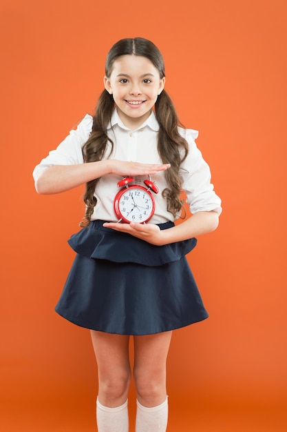 Dag tijd dagelijkse routine schema schoolmeisje en retro wekker Kinderen onderwijs Kennis dag School tijd tijd om naar school te gaan Gelukkig meisje houd wekker tellen voor lunchtijd