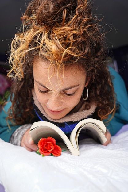 Dag van het boek Vrouw kijkt naar een roos die een boek leest Sant jordi in Catalonië